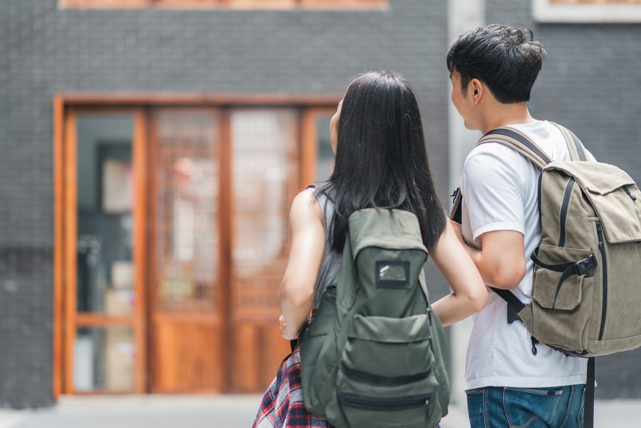 Traveler Asian backpacker couple feeling happy traveling in Beijing, China, cheerful young teenager couple walking at Chinatown. Lifestyle backpack tourist travel holiday in city concept.